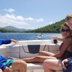 a group of people sitting next to a body of water