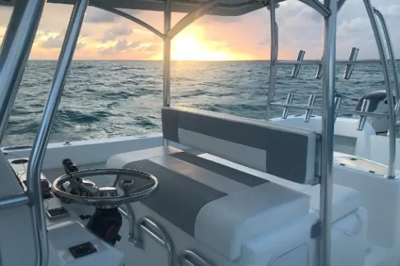 a boat that is sitting on a chair next to a body of water