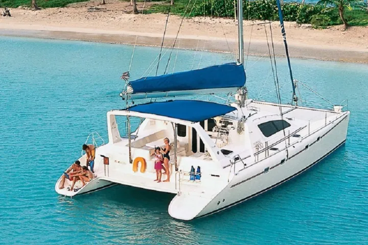 a blue and white boat sitting next to a body of water