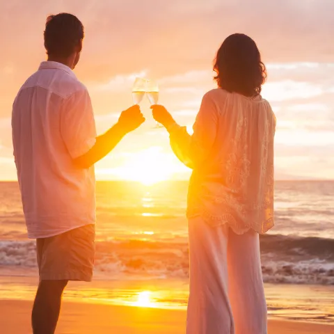 a man and a woman standing in front of a beach