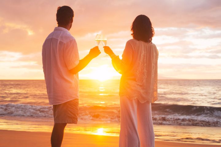 a man and a woman standing in front of a beach