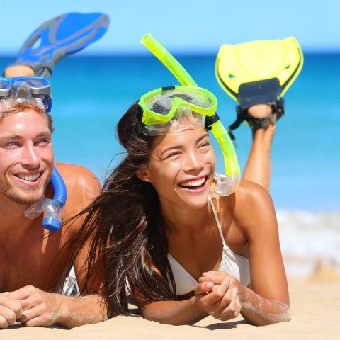 a group of people on a beach near a body of water