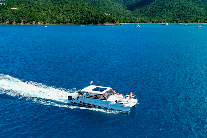 Seas the Day Charters USVI M/V Hydra leaving St. John with guests relaxing on the bow
