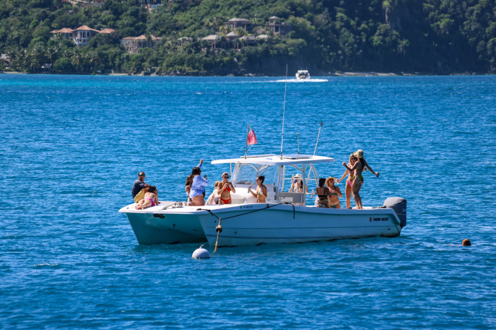 11 guests dancing aboard Seas the Day Charters USVI M/V Poseidon during their private powerboat charter on St. John