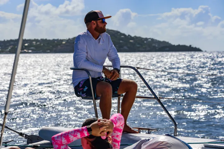 Guests sitting on bow tip of Seas the Day Charters USVI S/Y Leviathan, a private charter boat visiting St. Thomas and St. John in the US Virgin Islands