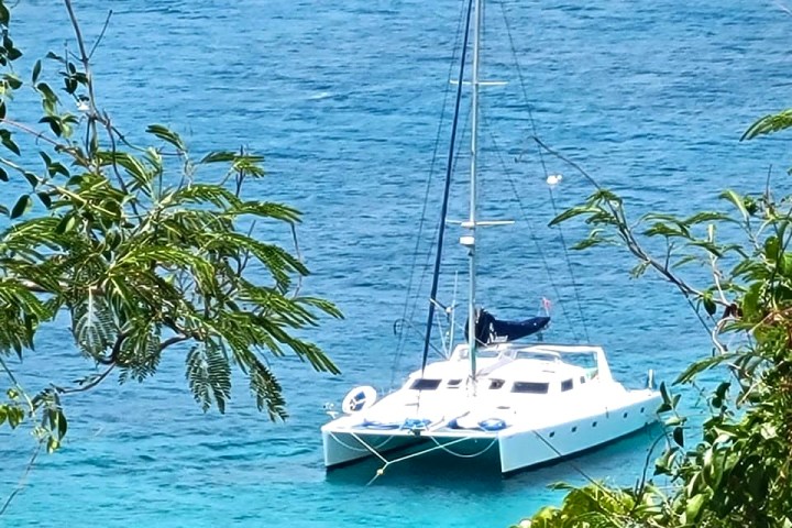 Seas the Day Charters USVI private charter boat SY Sirena seen from land, moored in Caribbean blue water