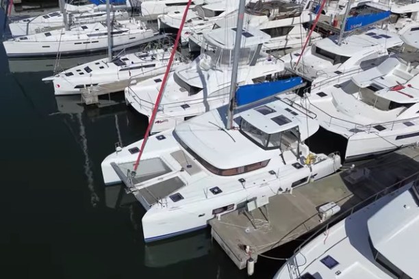 Aerial view of white catamarans docked in a marina.